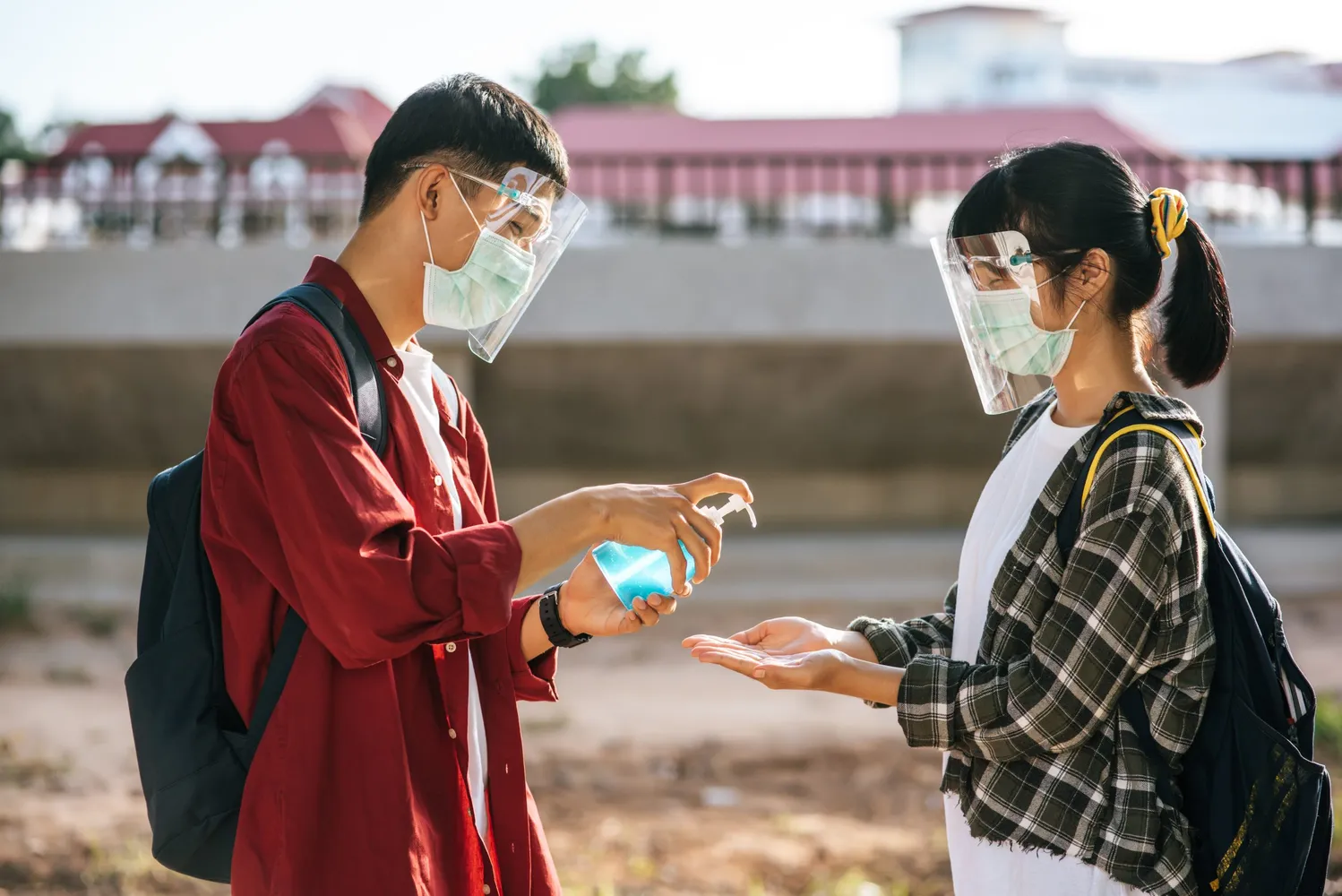 Male and female students wear masks and squeeze the gel to wash