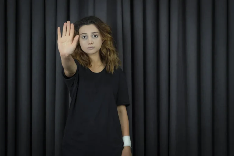 Portraits of depressed young girl putting her hand to the camera and gesture to stop